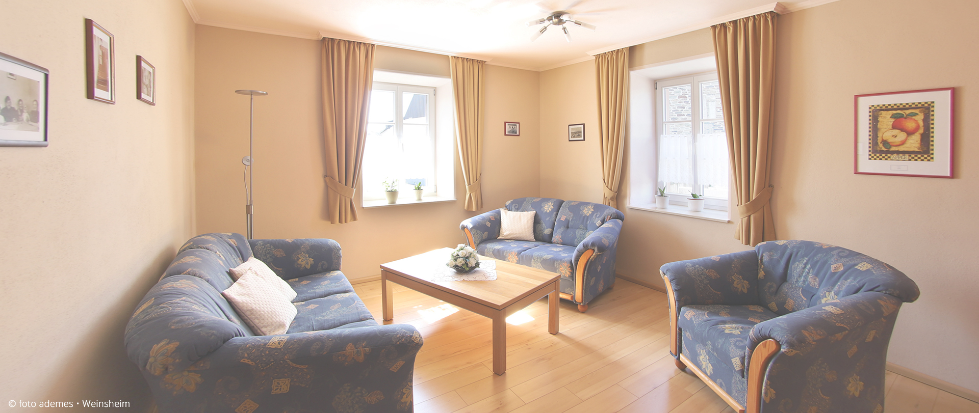 Blick ins Wohnzimmer mit Sofa, zwei Sesseln und Couchtisch