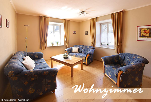 Wohnzimmer im ersten Stock mit Sofas, Armlehnsessel und Couchtisch