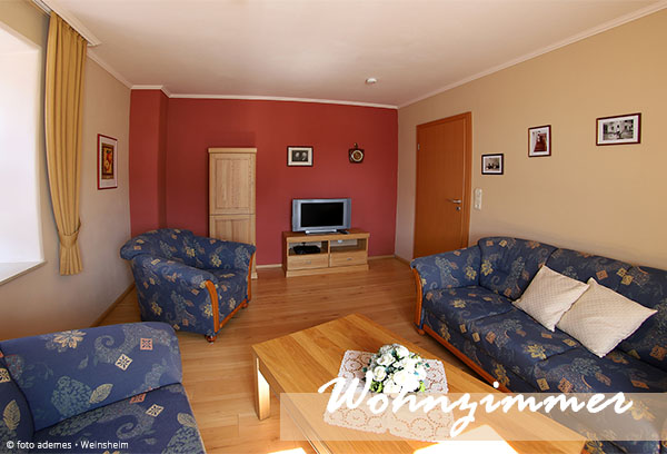 Wohnzimmer im ersten Stock mit Blick zu Zimmertür und Fernseher