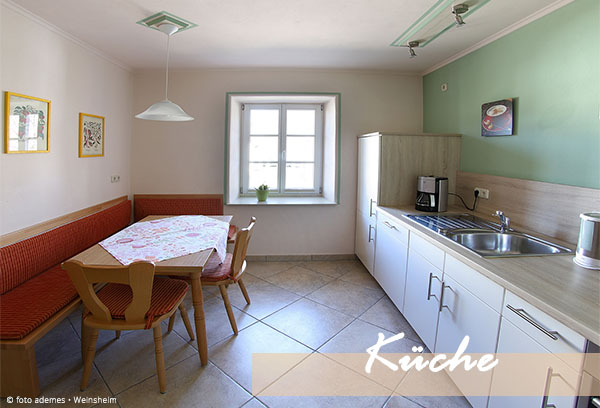 Küche mit großer Küchenzeile und Sitzecke mit Tisch, Stühle und Eckbank