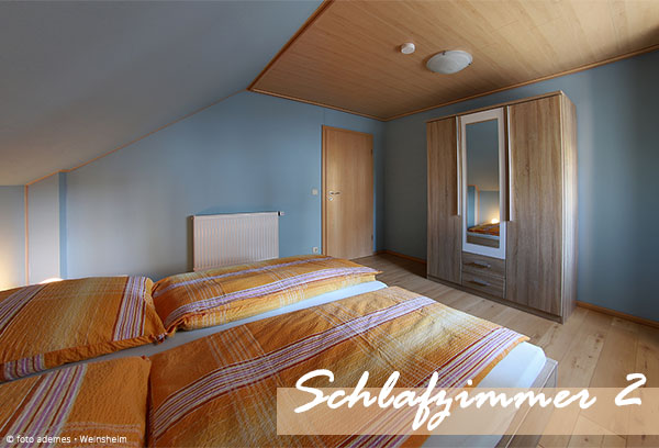 Schlafzimmer im Dachgeschoss mit Blick auf Kleiderschrank und Zimmertür